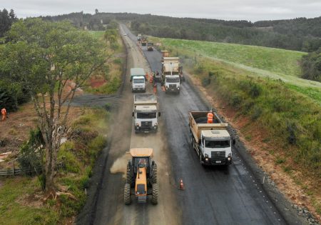 Camnhões e tratores asfaltando estrada no paraná