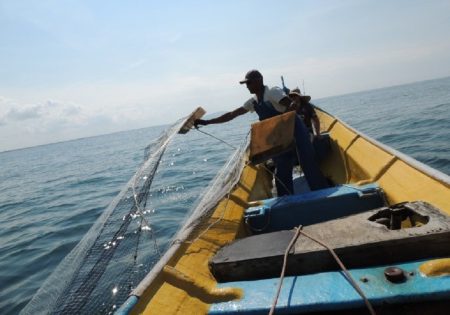 Pescador dentro de barco segurando rede