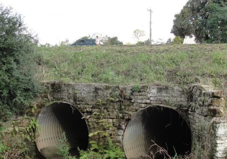 dois tubos por onde passa água sob uma estrada